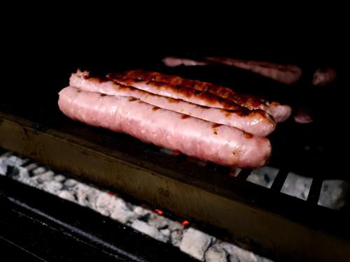 three pieces of meat cooking on a grill at Hospedium Hotel Lleida in Graus