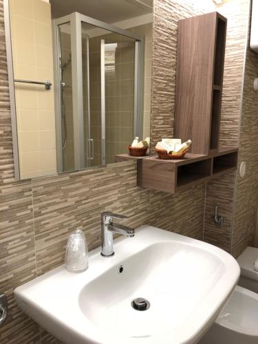 a bathroom with a sink and a mirror and a toilet at Hotel Le Tre Isole in Magione