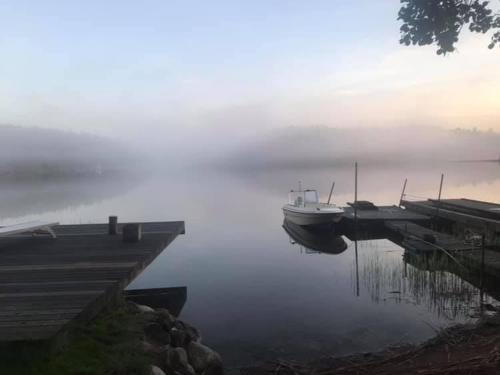 a boat is docked at a dock in the water at Fishermans cabin in Myttinge