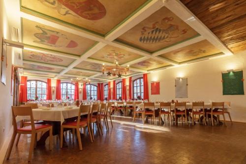 BIO-Hotel Alter Wirt في غرنوالد: غرفة طعام كبيرة مع طاولات وكراسي