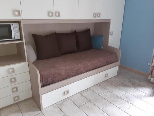 a bed in a small room with a microwave at EV 37 in Germignaga