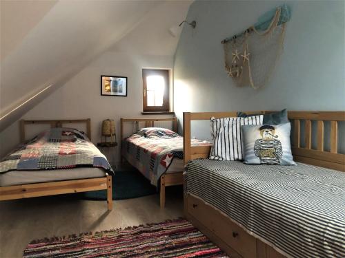 a bedroom with two beds and a bedskirts at Sea You Blue House in Rogowo
