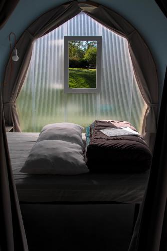 a bed in a tent with a window at Camping Au Coeur de Vendome in Vendôme