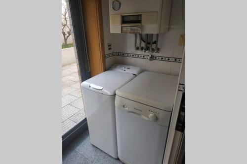 a small kitchen with a white washer and dryer at Diva Alojamento in Matosinhos