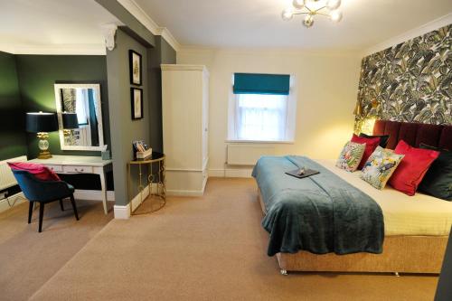 a bedroom with a bed and a desk and a mirror at The Cleveland in Torquay