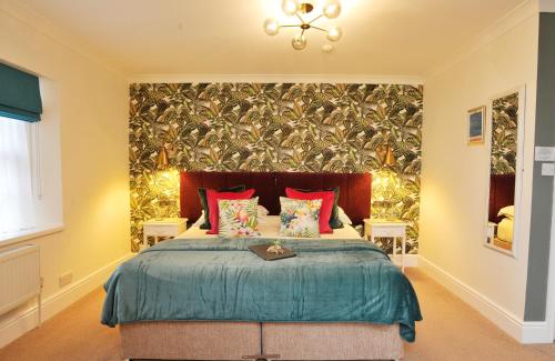 a bedroom with a large bed with red pillows at The Cleveland in Torquay