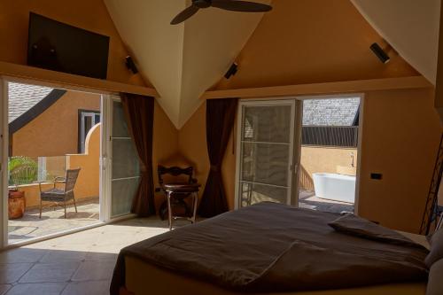 a bedroom with a bed and a balcony with a tub at Laguna Beach House in Ko Chang