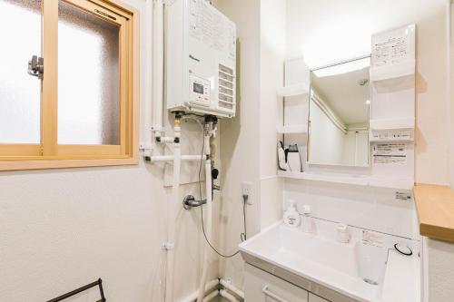 bagno con lavandino e specchio di TKD HOUSE Asahikawa a Asahikawa