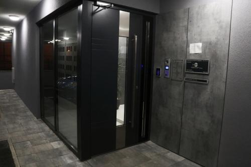a hallway with two glass elevators in a building at Apartman Natasa sa podzemnom garažom in Banja Luka