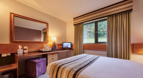 a hotel room with a bed and a mirror at Stirling Court Hotel in Stirling