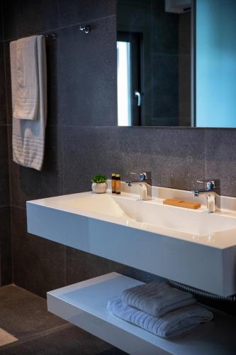 a bathroom with a white sink and a mirror at Adrianna Villa 4ppl in Bali