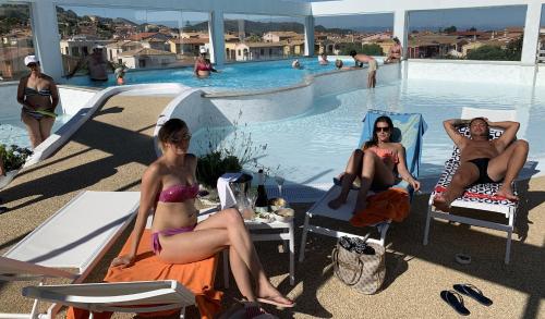 a group of women sitting in chairs by a swimming pool at Hotel Stele di Nora in Pula