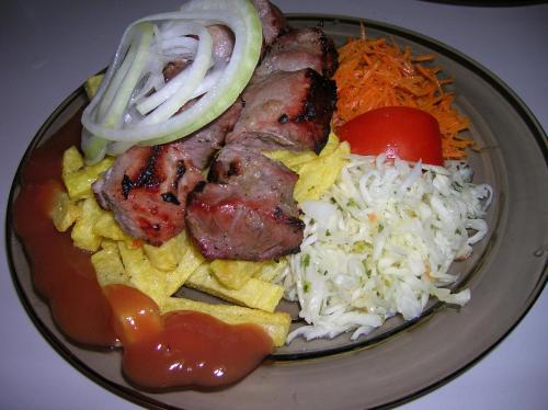 a plate of food with meat rice and vegetables at Tera in Saulkrasti