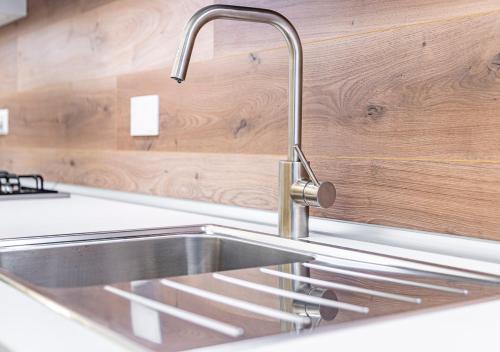 a stainless steel sink in a kitchen with wooden walls at CITy TURIN HUB in Turin