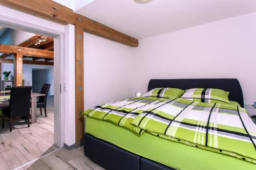 a bedroom with a green bed and a dining room at Ferienwohnungen Schwabenhof in Schramberg