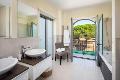 a bathroom with a sink and a toilet and a balcony at Shantiapartments in Vilamoura