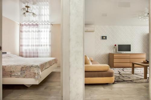 トリヤッチにあるАпартаменты на 40 лет Победы 49Дの白いベッドルーム(ベッド1台、テレビ付)