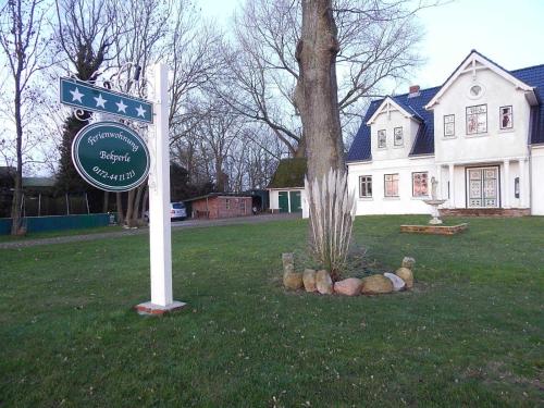 um sinal em frente a uma casa com uma casa em Ferienwohnungen Bekperle em Bekdorf