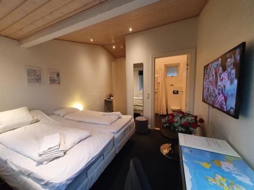 a hotel room with two beds and a tv at Bente's Guesthouse in Holstebro