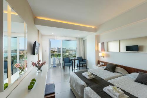 a bedroom with a bed and a living room at Melissi Beach Hotel & Spa in Ayia Napa
