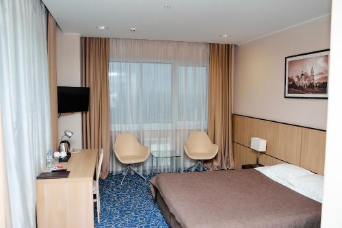 um quarto de hotel com uma cama e uma secretária em Vikonda Hotel em Rybinsk