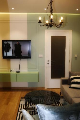 a living room with a couch and a tv on a wall at Apartman Natasa sa podzemnom garažom in Banja Luka