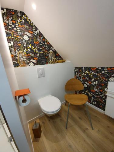 a room with a chair and a painting on the wall at "Au jardin sur l'eau" Hortillonnages in Amiens