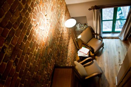 a living room with two chairs and a wall at B&B Haspenhoeve in Tongeren