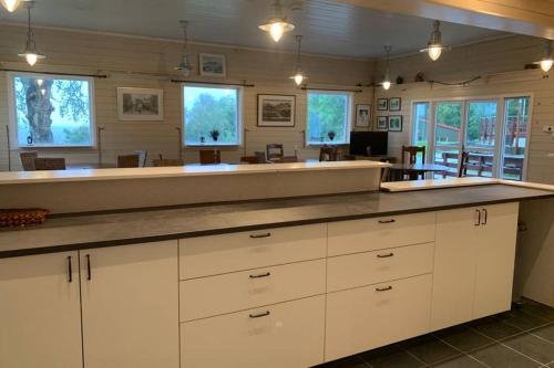 a large kitchen with white cabinets and a large counter at Moldegaard Riding Lodge in Moldegard