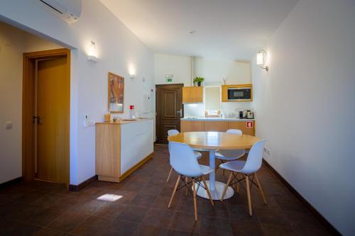 a kitchen with a table and chairs in a room at Casas do Almourão in Foz do Cobrão