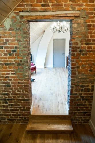 an old brick wall with a mirror in a hallway at B&B Haspenhoeve in Tongeren
