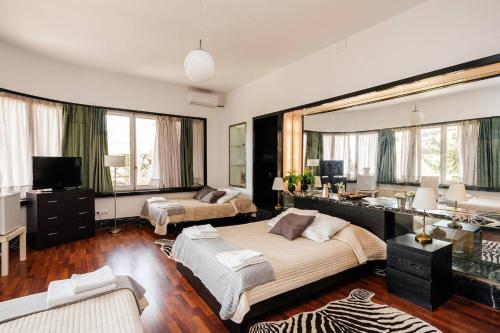 a bedroom with a large bed and a living room at Casa Vilaró Park Guell in Barcelona