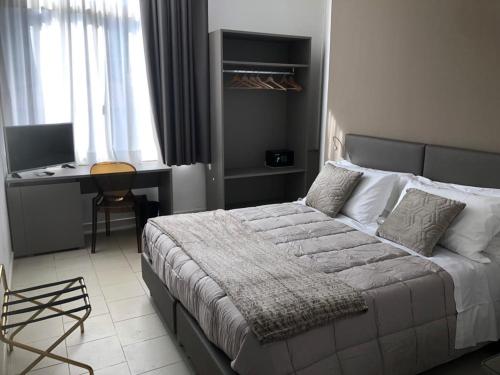 a bedroom with a bed and a desk in it at Hotel Inn in Giardini Naxos