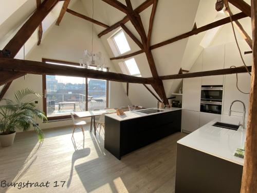 a large kitchen with a large window at Burgstraat 17 Apartment in Exclusive Patrician House in Medieval Ghent in Ghent