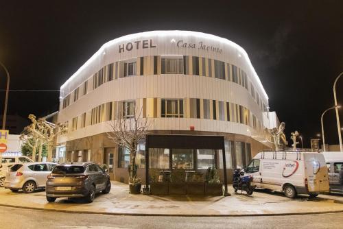 a hotel building with cars parked in front of it at Hotel Casa Jacinto Pamplona in Burlada
