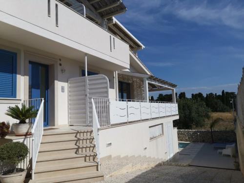 une maison blanche avec des escaliers et un balcon. dans l'établissement Villa Sea Sky - Sicily In, à Pozzallo