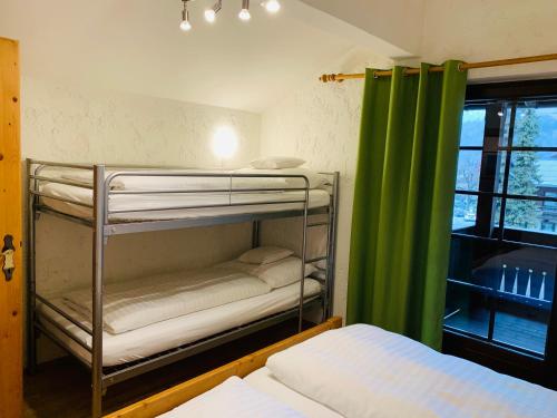 Cette chambre comprend des lits superposés et un rideau vert. dans l'établissement Appartement Azalea Oetz, à Oetz