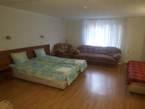 a bedroom with a bed and a living room with a couch at Hotel Zora in Velingrad