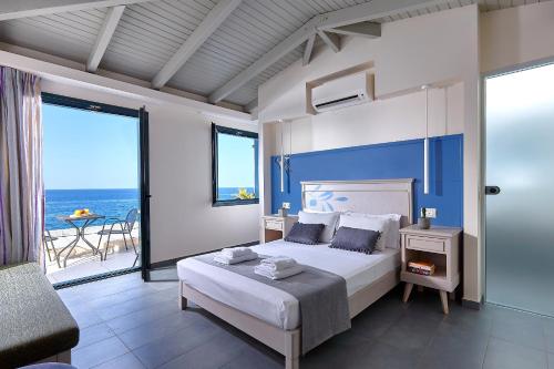 a bedroom with a bed and a view of the ocean at Castello Village Resort in Sissi