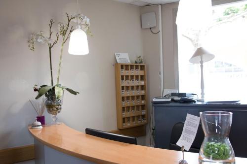 an office with a desk and a vase with flowers on it at Hotel Casa Jacinto Pamplona in Burlada