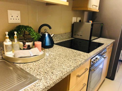 una cucina con piano di lavoro e forno a microonde di Umhlanga Ridge self-catering apartment a Durban