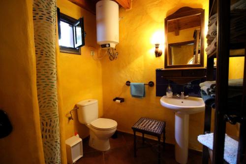 a yellow bathroom with a toilet and a sink at Casa Roco 2 in Tías