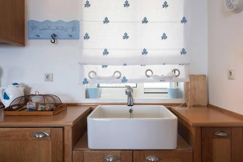 une cuisine avec un évier blanc et une fenêtre dans l'établissement Lavender House (Glyfada beach), à Glyfada