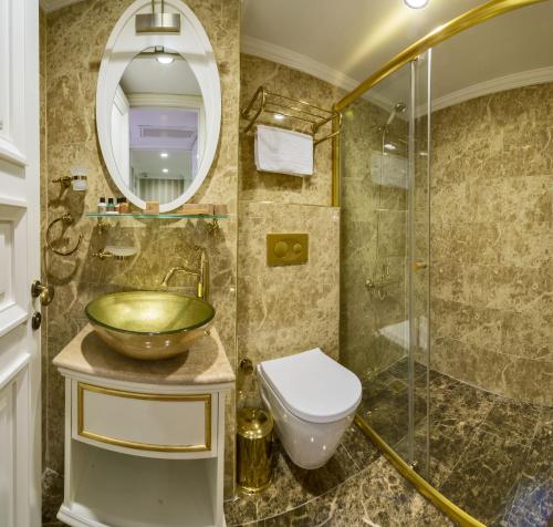 a bathroom with a sink, toilet and bathtub at Alpek Hotel in Istanbul