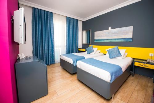 a hotel room with two beds and a tv at Mera Park Hotel in Antalya