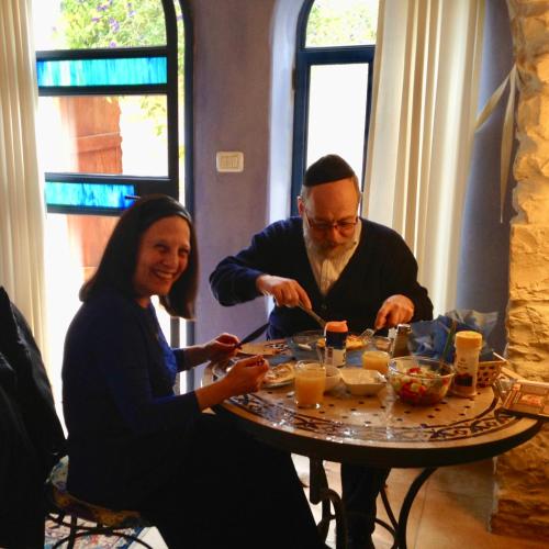 a man and woman sitting at a table eating food at Artist Quarter Guesthouse B&B in Safed