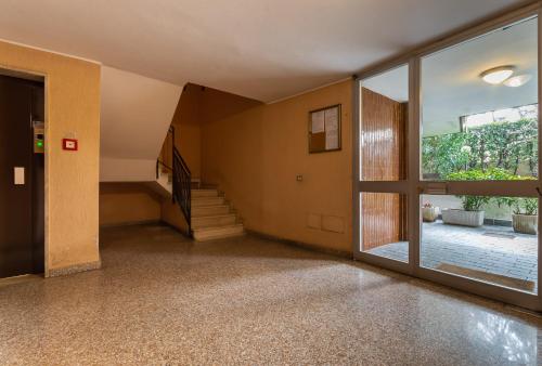 pusty pokój ze schodami i szklanymi drzwiami w obiekcie Cà Amisa w mieście Trezzano sul Naviglio