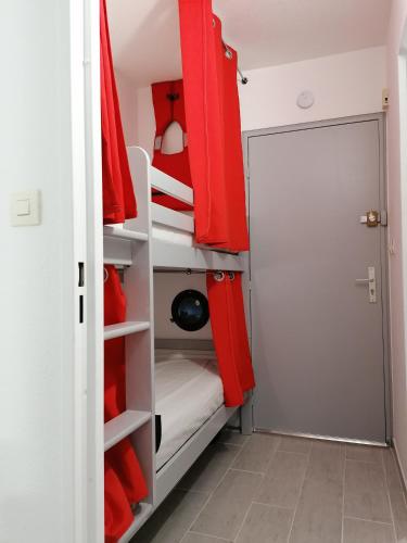 un placard avec des étagères rouges et blanches et une porte dans l'établissement La mer à 3 minutes, la clé d'un séjour réussi !, à Saint-Cyr-sur-Mer