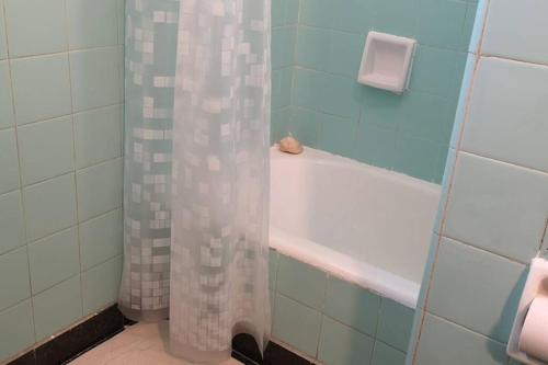a bathroom with a tub and a shower curtain at 2 ambientes en Almagro en Av Corrientes para 2 personas in Buenos Aires