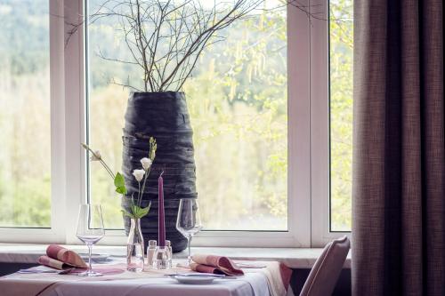 a table with a vase on top of a window at Golfhotel Fahrenbach in Tröstau
